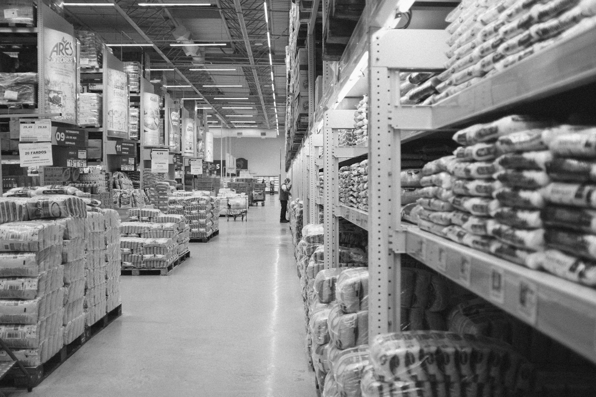 Shelves and pallets of packaged staple foods in a distribution warehouse